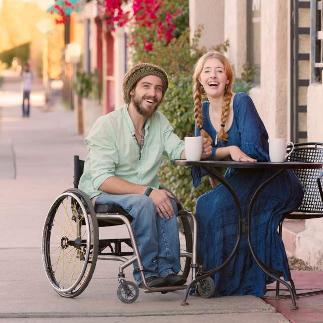 Guy in Wheelchair with Women drinking coffee at outdoor table