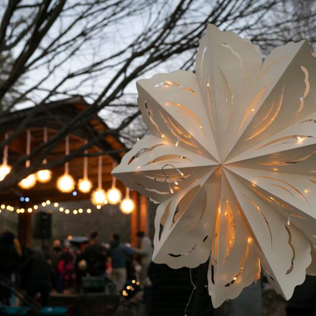 Up close image of a handmade lantern with the Eno River Farmers Market Pavilion in background