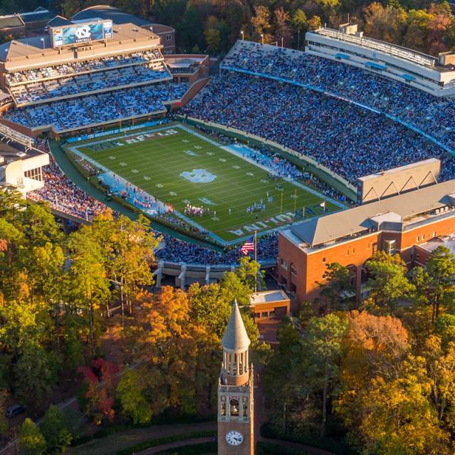 Football game at Kenan Stadium surrounded by fall foliage