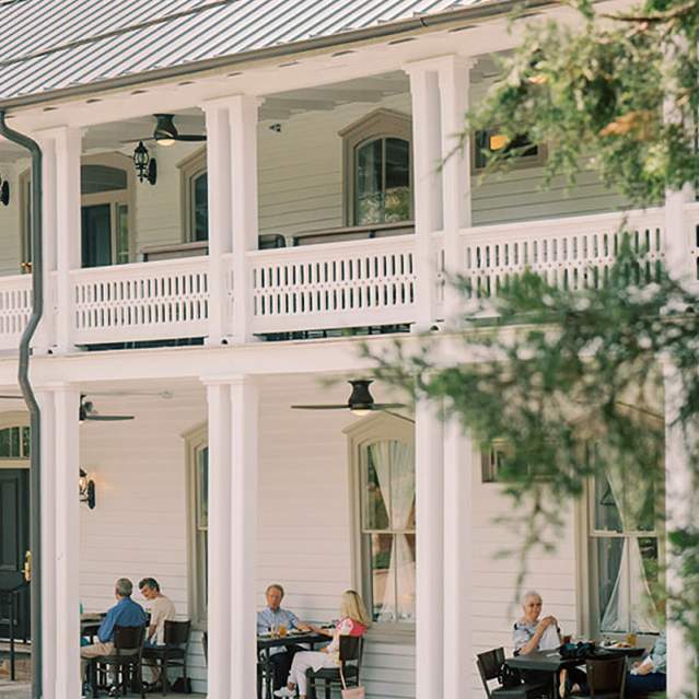 People dining outside on the porch of the Colonial Inn in Hillsborough