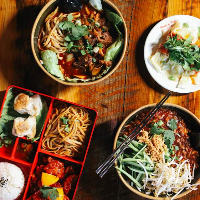 An array of dishes sit on a wooden table.