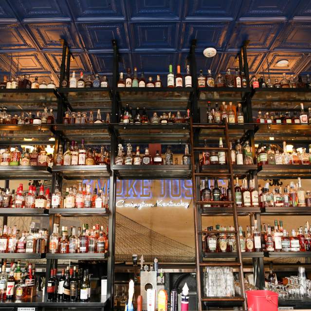 A tall shelf system with 12 shelves holding more than 500 bottles of bourbon