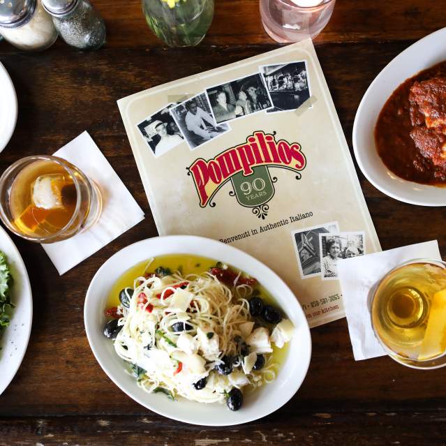 Pompilios menu surrounded by various cocktails, appetizers, and entrees.