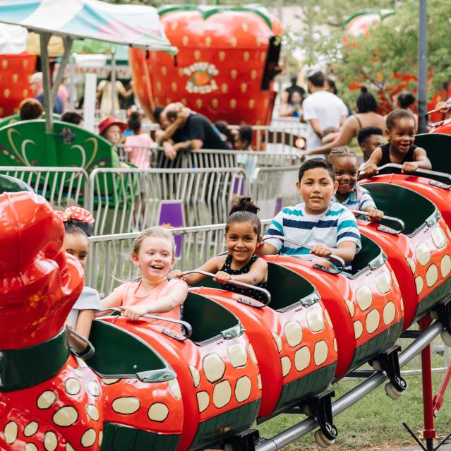 children enjoying a ride on a small roller coaster