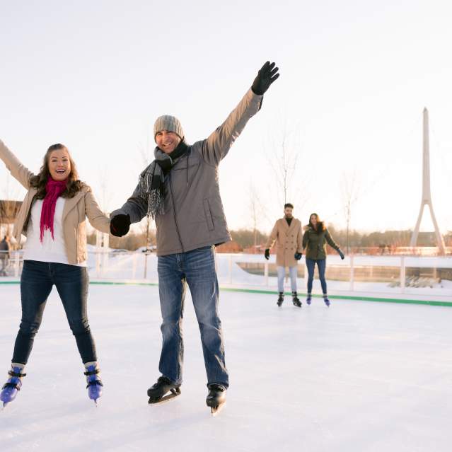 Two couples ice skating in Riverside Crossing Park