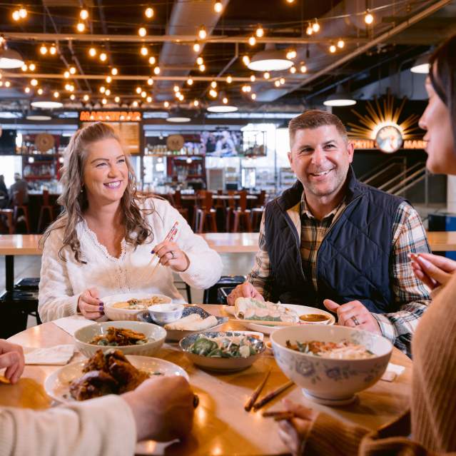 Two couples enjoying food at a community table in North Market Bridge Park