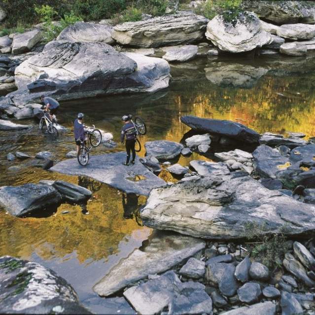 Men crossing the Big South Fork National River with their bikes