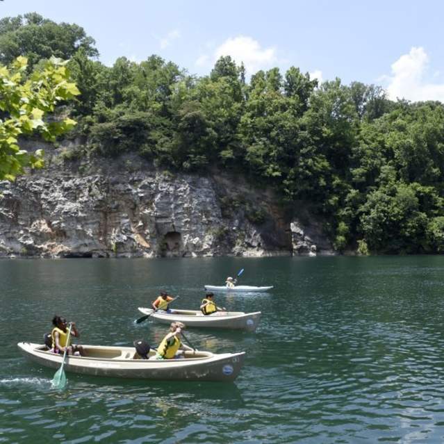 People enjoy the water on paddle boards and in canoes at Meads Quarry in Knoxville, TN