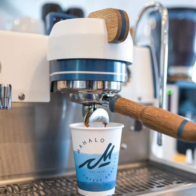 Fresh espresso from Mahalo Coffee Roasters is poured into a customer's drink.