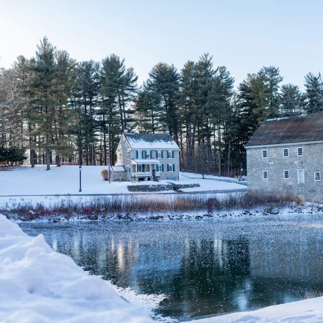 Snowy photo of Gring's Mill with a frozen lake