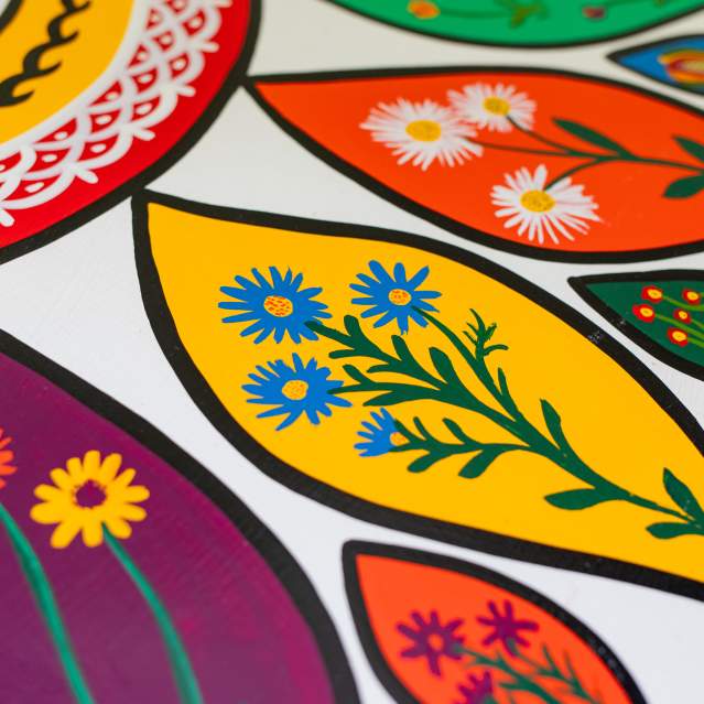 a close up shot of a hex sign painted with bright florals.