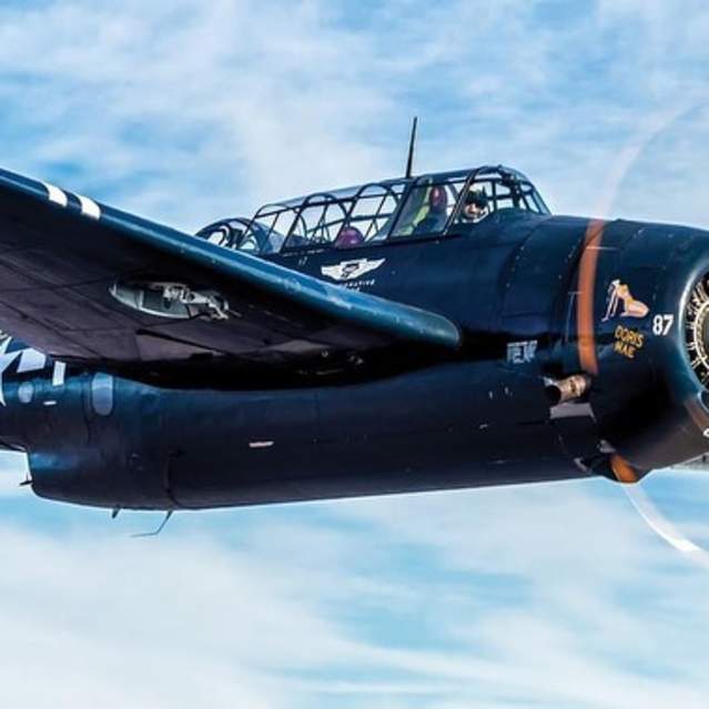 Plane from WWII Weekend flying through blue skies