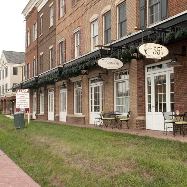 View of the exterior building with shop signs hanging in the town of Haymarket