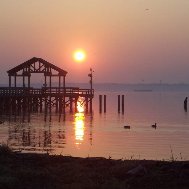 A beach with a boardwalk at sunset