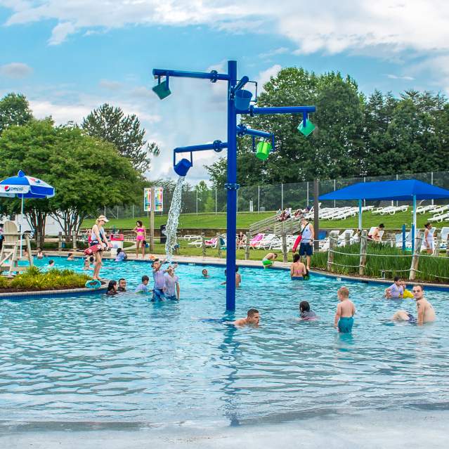 Lifeguards watching over a pool filled with guests in the summer