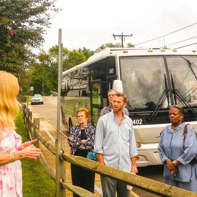 group of adults in front of a bus