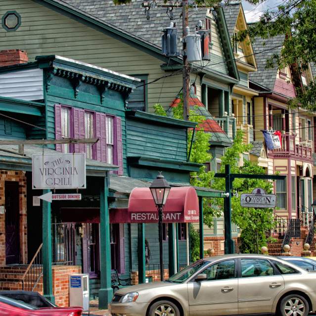 Colorful historic storefronts with cars parked outfront