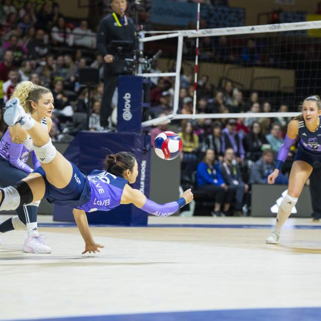 A volleyball player dives for a save