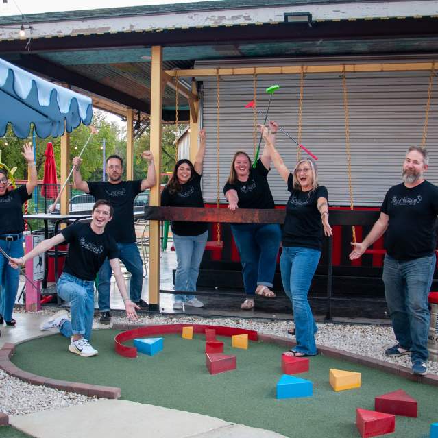 The Visit San Marcos team pose after a rousing game of Putt Putt golf at Putt Pub in Downtown San Marcos, Texas