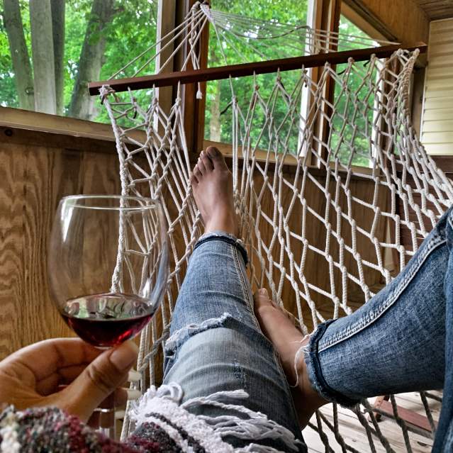 woman in hammock relaxing with wine