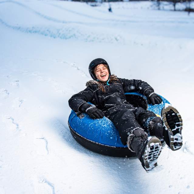 child tubing in snow