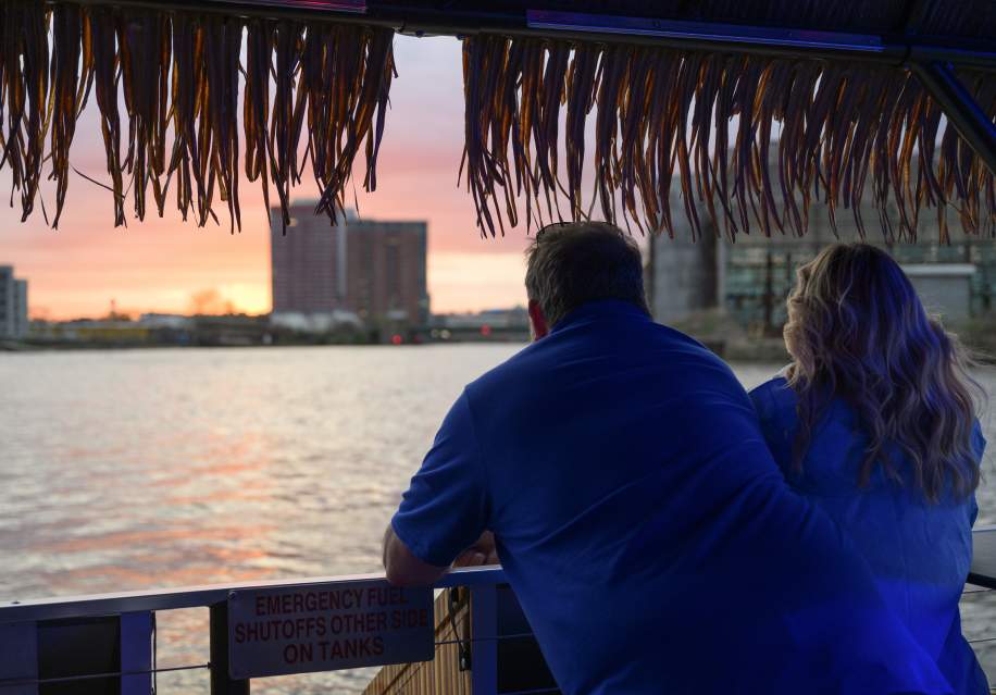 Man and woman looking out over the riverfront at sunset
