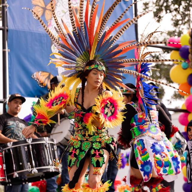 Performer in traditional attire dancing during Denison’s Dia de los Muertos celebration