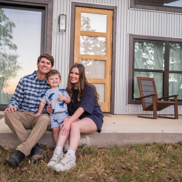 Family posing together on their cabin's front porch at Texas Tiny Cabins