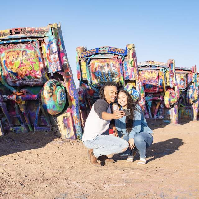 Couple taking a selfie in front of cadillac ranch in Amarillo, texas