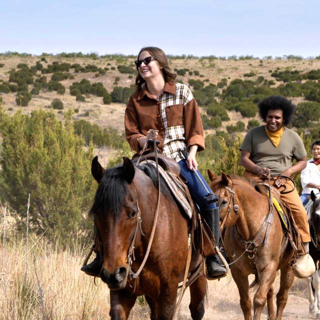 group of people horseback riding smiling