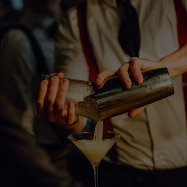 Bar patrons holding martini glasses