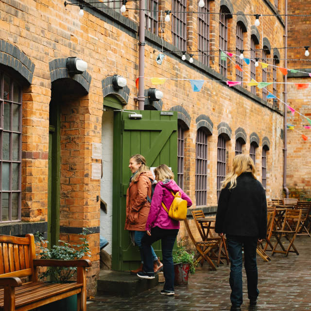 Three women walk into a building.