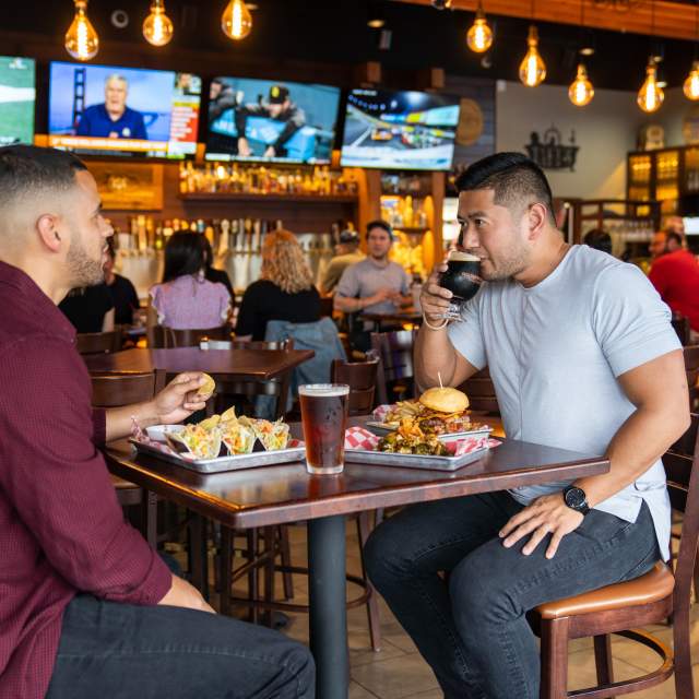 two men enjoying beer and food at 859 taproom
