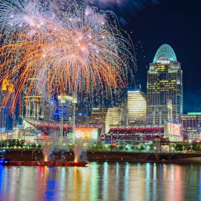 The Cincinnati skyline at night with fireworks going off in front of the Great American Ballpark