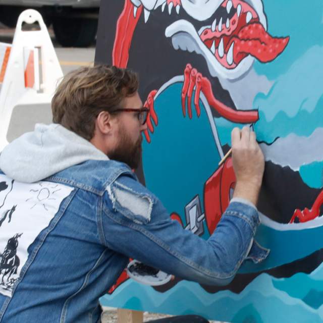 Man painting mural during Scrawl event in Franklinton