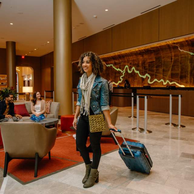 Woman rolling suitcase through Hilton Columbus Downtown, Tower 402