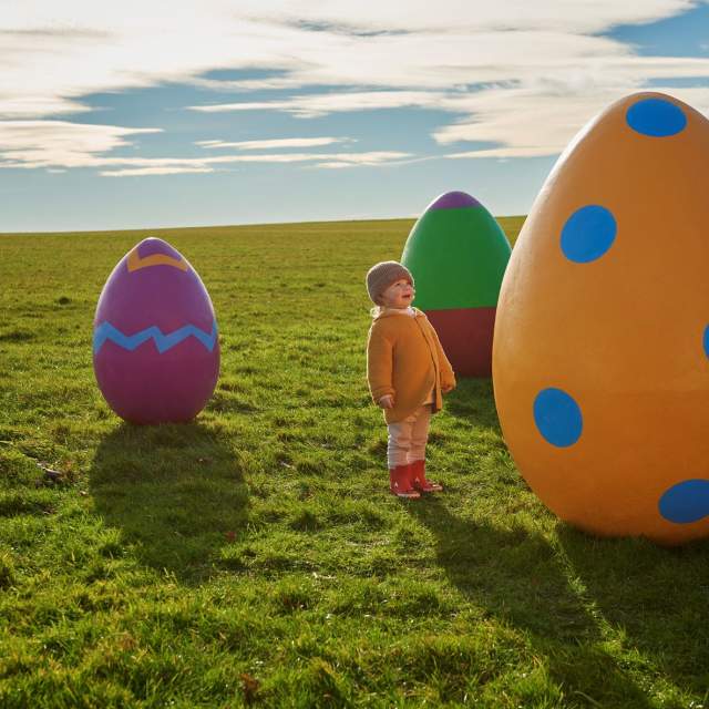 child with giant easter eggs