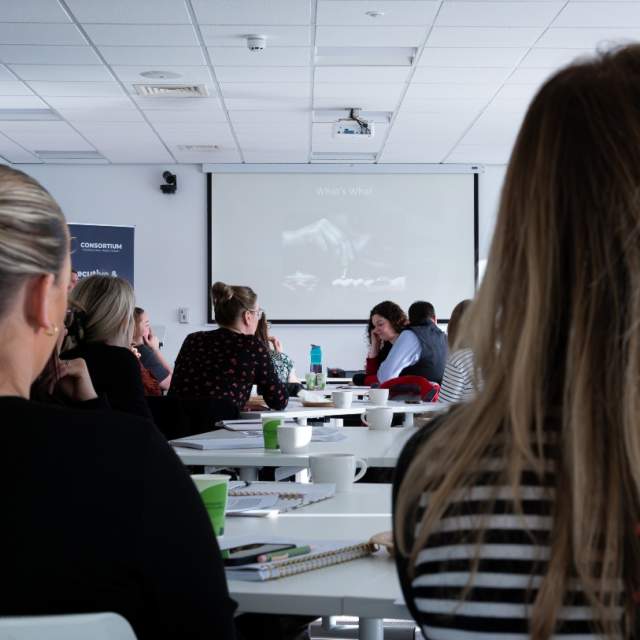 participants of a business workshop, facing the front screen.
