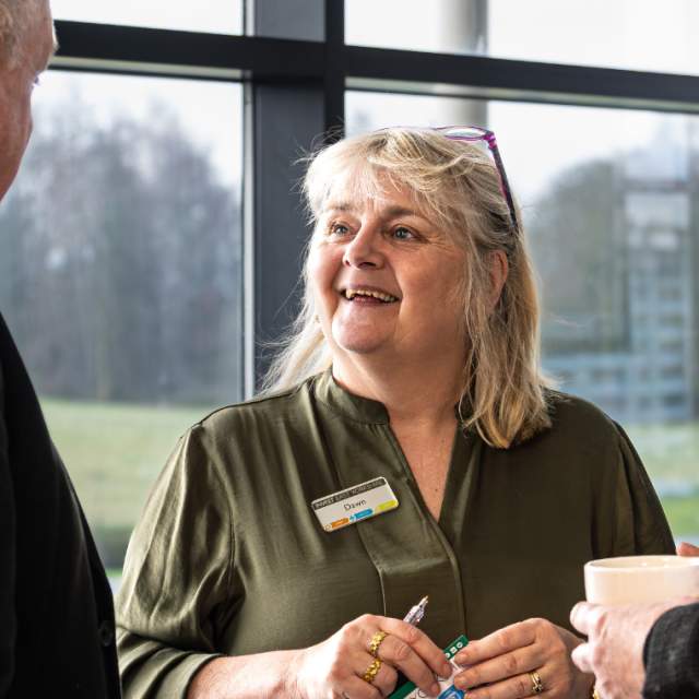 Three people chatting at a business network meeting.