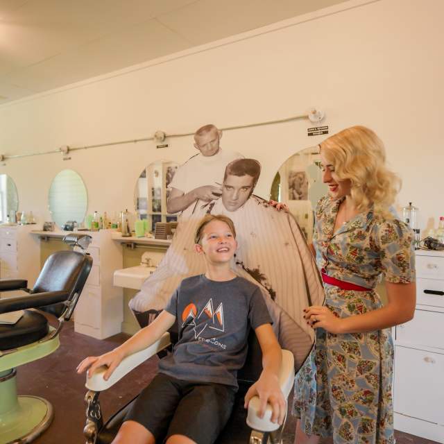 A child sits in the Elvis chair at the Chaffee Barbershop Museum, Fort Smith, Arkansas.