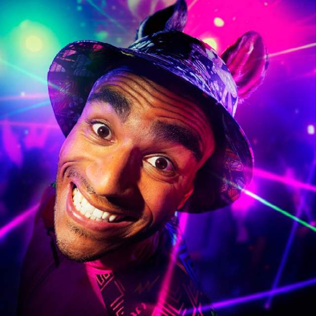 An actor poses in front of coloured laser lighting
