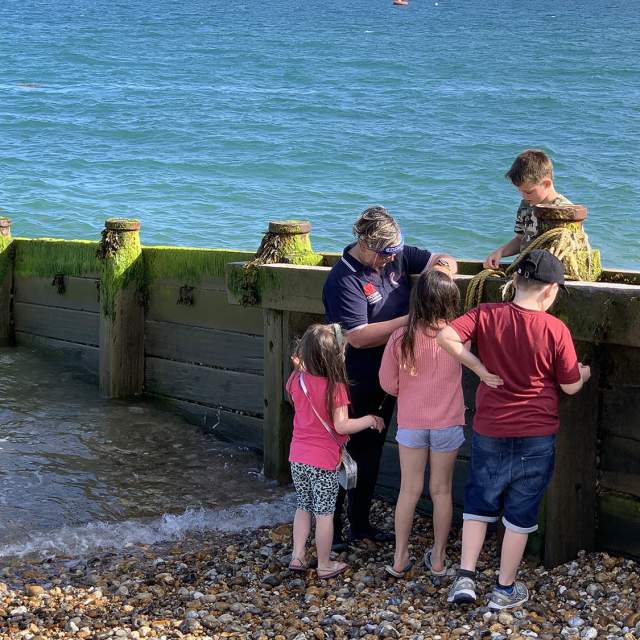 A group of children on a beach with waves coming in