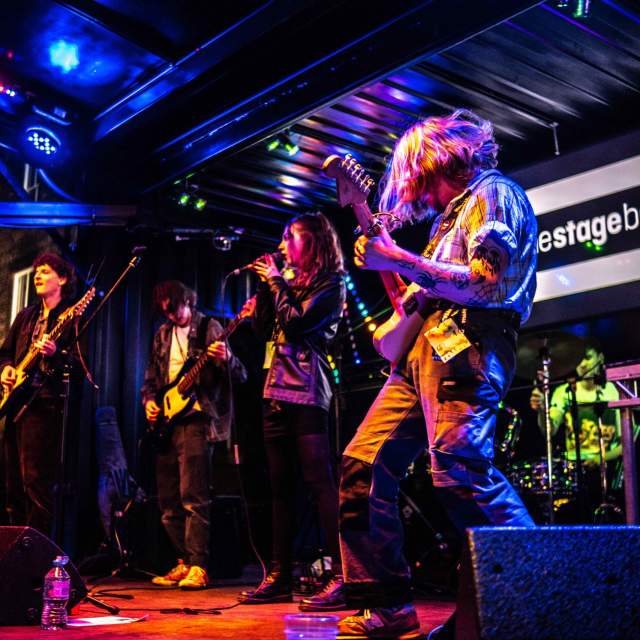 A band on stage with the Warren Project