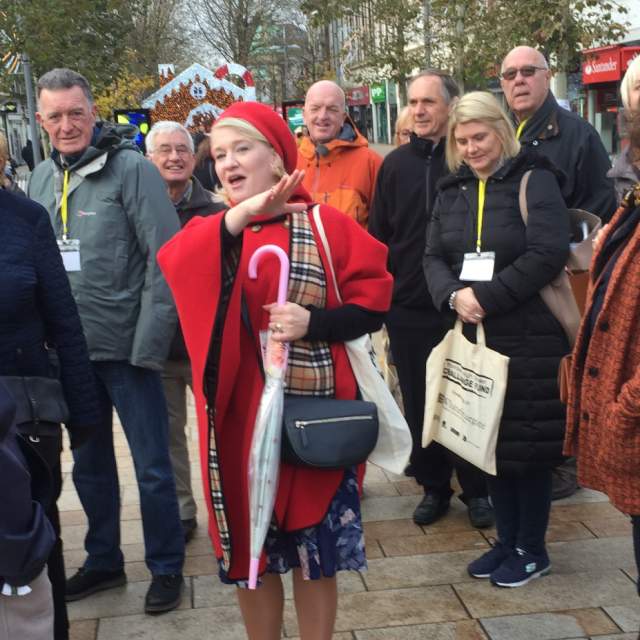 A guided group tour in Hull city centre, with visitors gathered around a tour guide during a walking tour of the city's historic and cultural attractions.