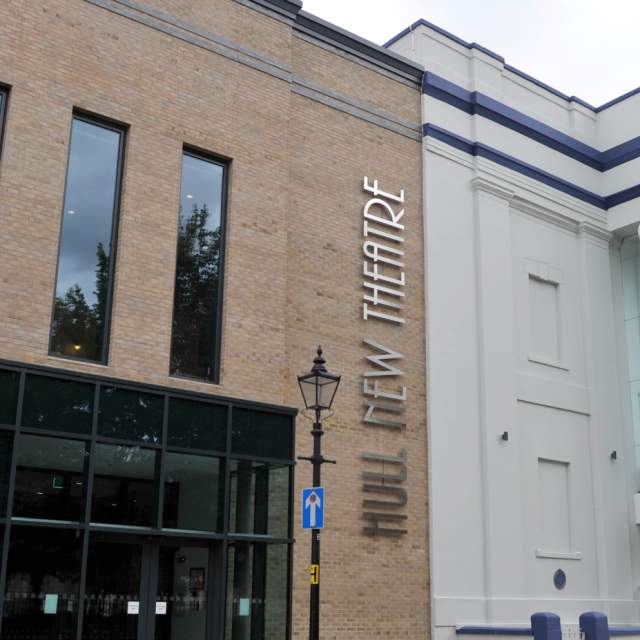 Exterior view of Hull New Theatre showing its modern glass extension and grand white columned façade in the city centre of Hull.