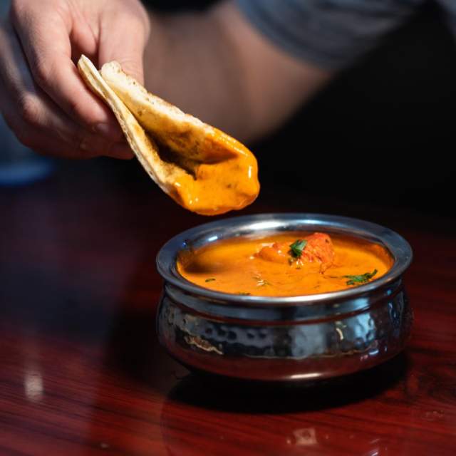 bread being dipped into orange soup