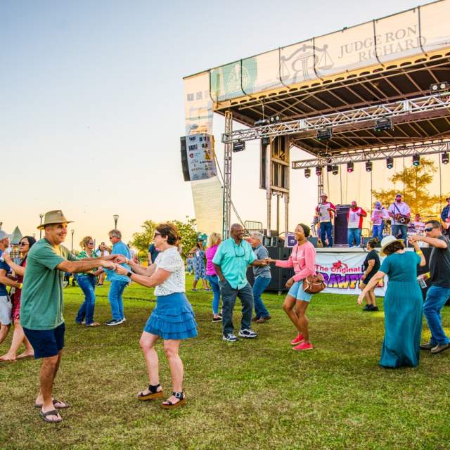 men and women dance in front of the stage at the event center amphitheater for This is Home Fest