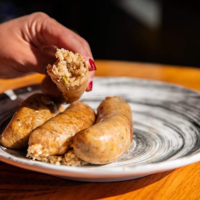 three links of boudin one held in hand