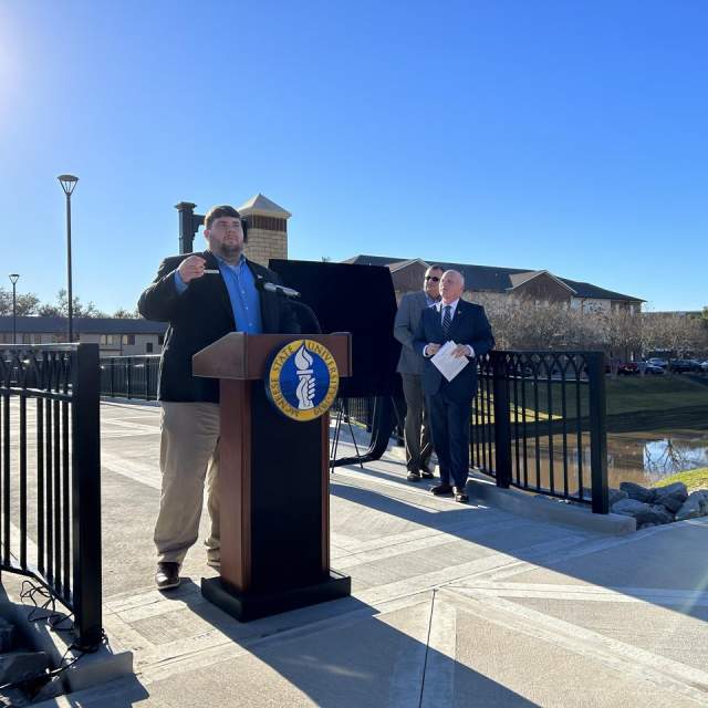 man stands at podium in mcneese district