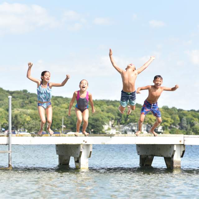 A group of kids jumping off the pier at Riviera Beach